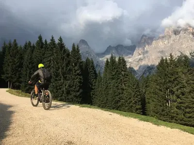 a man riding a bike down a dirt road at CASA BERNARD Zortea VANOI cuore verde del Trentino in Canale San Bovo