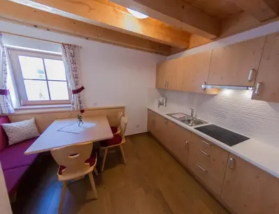 a small kitchen with a table and a sink at Panzenbachhof in Valdaora di Sotto