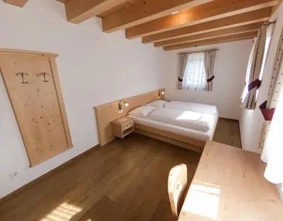a bedroom with a bed and a wooden floor at Panzenbachhof in Valdaora di Sotto