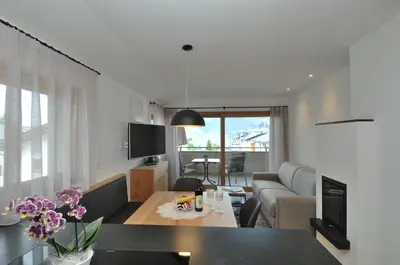 a living room with a couch and a table with flowers at Apartments Helga in Castelrotto