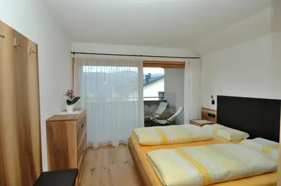 a bedroom with two beds in a room with a window at Apartments Helga in Castelrotto