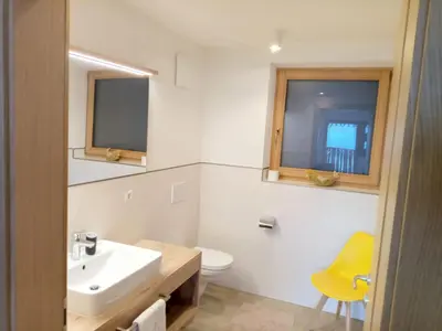 a bathroom with a sink and a toilet and a window at Obergereuth Hof 2021 in San Martino