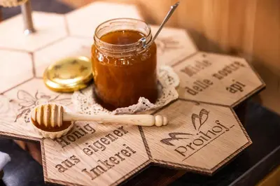 a jar of honey and a spoon on a table at Proihof in Funes