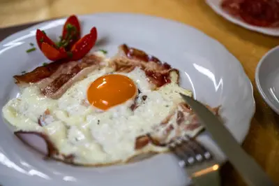 a white plate with an egg on top of food at Proihof in Funes