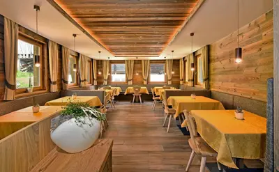 a restaurant with tables and chairs and wooden walls at Proihof in Funes