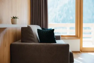 a chair with a pillow in a room with a window at Aria de Munt in San Vigilio Di Marebbe