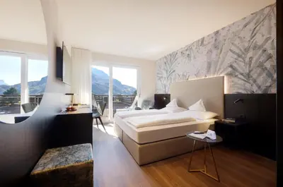 a hotel room with a bed and a desk at Hotel Ladurner in Merano