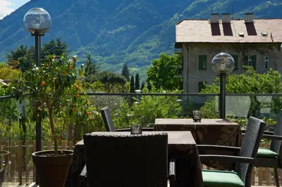 two beds with white pillows and a picture on the wall at Hotel Ladurner in Merano