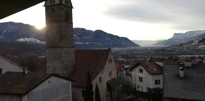 a view of a town with a tower and buildings at Ferienwohnungen St Hippolyt mit Hallenbad in Lagundo