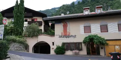 a building with a sign on the side of it at Ferienwohnungen St Hippolyt mit Hallenbad in Lagundo
