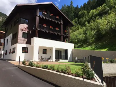 a building with a balcony with flowers on it at Chalet Miriam in Selva di Val Gardena
