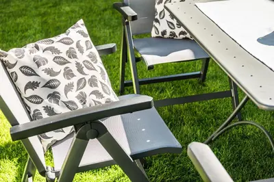 a chair with a pillow sitting next to a picnic table at Chalet Miriam in Selva di Val Gardena