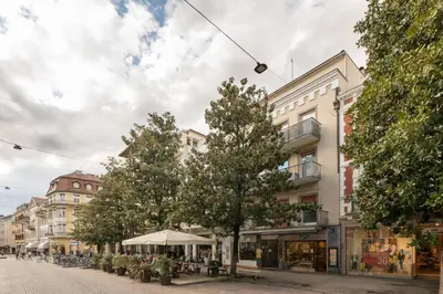 a street in a city with trees and buildings at Merano-biz in Merano