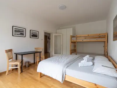 a bedroom with a bed and a table and a desk at Merano-biz in Merano