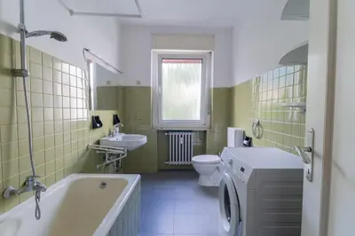 a bathroom with a tub and a toilet and a sink at Merano-biz in Merano