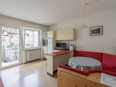 a living room with a red couch and a kitchen at Merano-biz in Merano