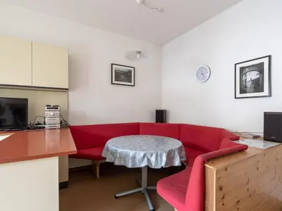 a living room with a red couch and a table at Merano-biz in Merano