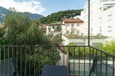 a balcony with a view of buildings and mountains at Merano-biz in Merano