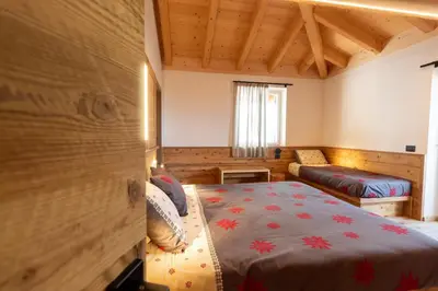 a bedroom with a bed and a couch in a room at Agritur Fiordaliso in Predaia