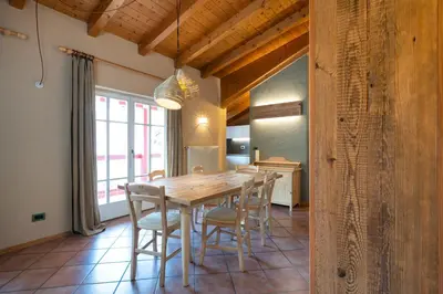 a dining room with a wooden table and chairs at Ciasa Buro - Gimel in Moena