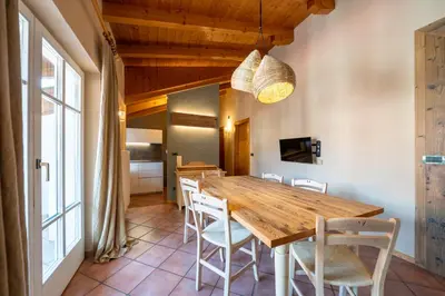 a dining room with a wooden table and chairs at Ciasa Buro - Gimel in Moena