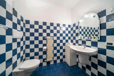 a blue and white bathroom with a toilet and a sink at Ciasa Buro - Gimel in Moena
