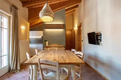 a dining room with a wooden table and chairs at Ciasa Buro - Gimel in Moena