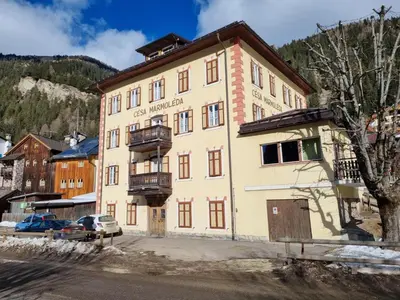 a large yellow building with a balcony at CHENINA in Canazei