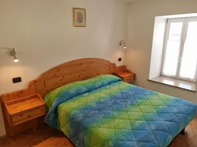 a bedroom with a wooden bed with a colorful comforter at CHENINA in Canazei