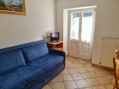 a living room with a blue couch and a television at CHENINA in Canazei
