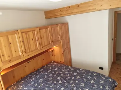a bedroom with a bed and wooden cabinets at CHENINA in Canazei