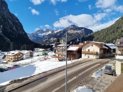 a town in the mountains with snow on the ground at CHENINA in Canazei