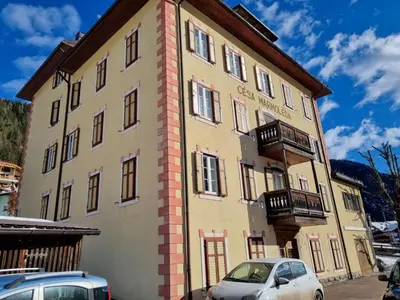 a building with cars parked in front of it at CHENINA in Canazei