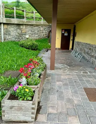 a garden with flowers in wooden boxes next to a building at EMARGHE, CASA A MOENA in Moena