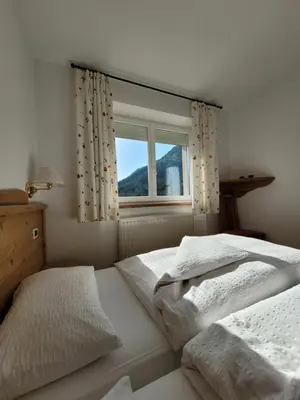 a bedroom with two beds and a window at Apartments Alpenroyal Arabba - Check-in at Garni Royal in Arabba
