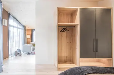 a bedroom with a wooden cabinet in a room at Erika Suites & Lofts in Stanghe
