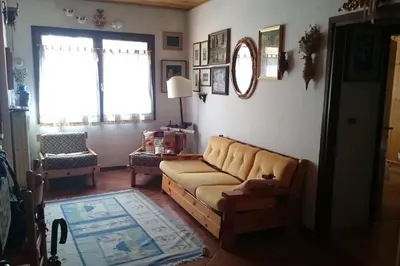a living room with a couch and a window at MirarMonti nel cuore di Pozza con i tuoi animali in Pozza di Fassa