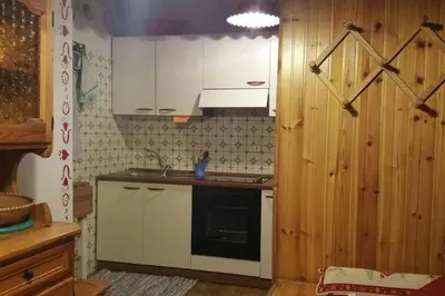 a kitchen with white cabinets and a stove top oven at MirarMonti nel cuore di Pozza con i tuoi animali in Pozza di Fassa
