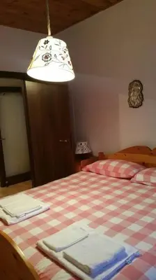 a bedroom with a bed with a checkeredkered blanket at MirarMonti nel cuore di Pozza con i tuoi animali in Pozza di Fassa