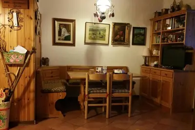 a dining room with a table and a television at MirarMonti nel cuore di Pozza con i tuoi animali in Pozza di Fassa