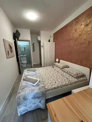 a bedroom with a large bed and a mirror at Capri B&B in Bolzano