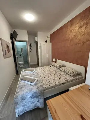 a small bedroom with a bed and a bathroom at Capri B&B in Bolzano