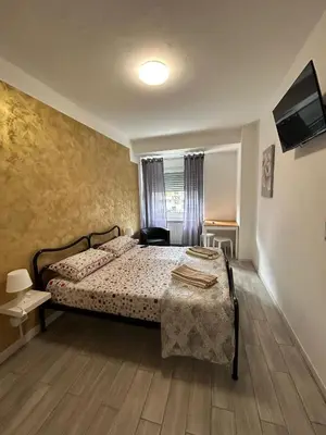 a bedroom with a bed and a tv on the wall at Capri B&B in Bolzano