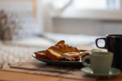 a plate of bread and a cup of coffee on a table at Capri B&B in Bolzano
