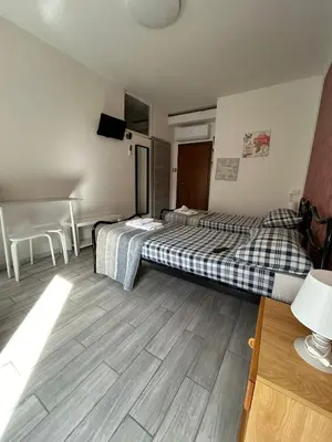 a hotel room with two beds and a table at Capri B&B in Bolzano