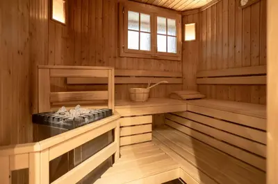 a sauna with a tub in a wooden cabin at B&B Garni Villa Campitello in Campitello di Fassa