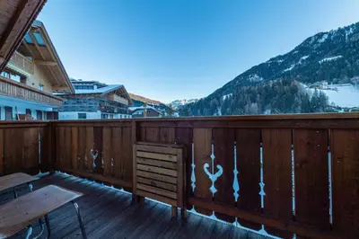 a wooden balcony with a table and a bench on it at Apartments Agave in Ortisei