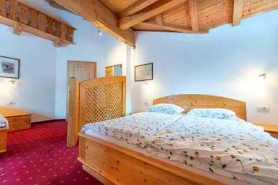 a bedroom with a wooden bed with a wooden headboard at Apartments Agave in Ortisei