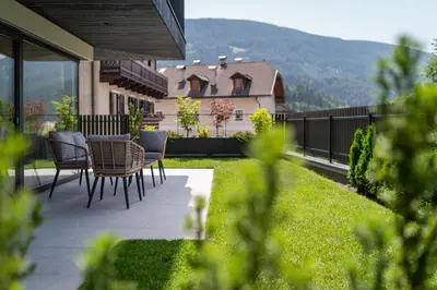 a patio with chairs and a table on a house at VANEA - Alp Relax Guesthouse in Chienes
