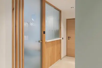 a hallway with a wooden door and a window at VANEA - Alp Relax Guesthouse in Chienes